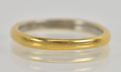 Lot 1230 - A 22ct yellow gold and platinum wedding band,...