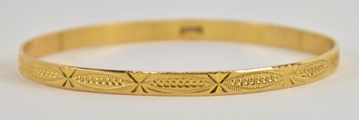 Lot 1409 - A yellow metal bangle, with indistinct...