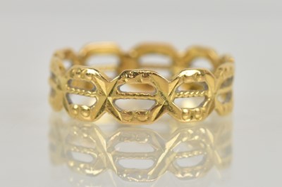 Lot 1266 - A yellow metal pierced band ring, with...