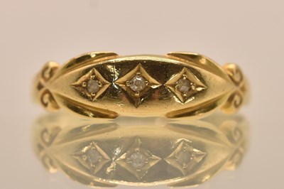 Lot 1240 - An 18ct yellow gold three stone diamond set...