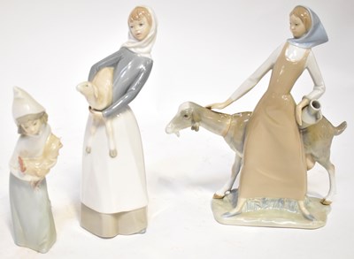 Lot 133 - LLADRO; three figures, a lady stroking a goat,...