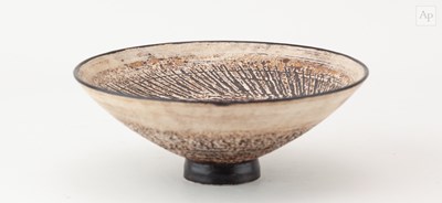 Lot 744 - A stoneware bowl covered in white slip over...
