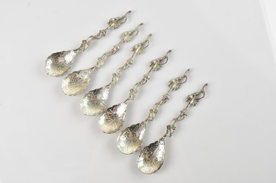 Lot 1534 - Six white metal teaspoons with cast floral...