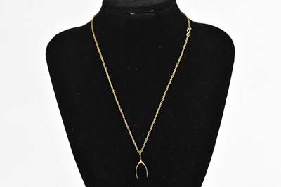 Lot 398 - A 9ct yellow gold wishbone pendant, suspended...