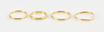 Lot 556 - Four yellow metal wedding bands, sizes T, Q, T...
