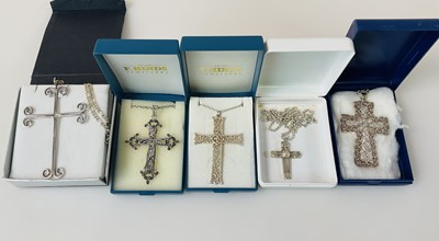 Lot 384 - Five silver/white metal cross pendants on...