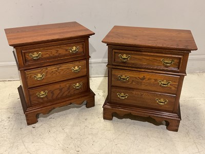 Lot 1110 - A pair of reproduction oak three drawer...