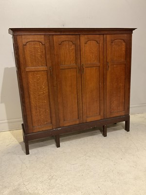 Lot 1097 - An Edwardian Arts and Crafts style oak...