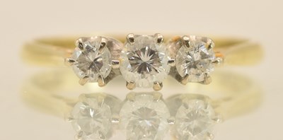 Lot 1287 - An 18ct yellow gold and platinum three stone...