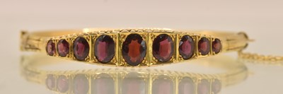 Lot 1459 - A 9ct yellow gold hinged bracelet set with...
