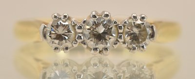 Lot 1237 - An 18ct yellow gold three stone diamond set...