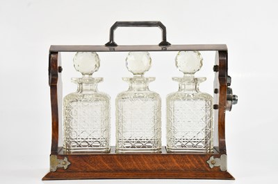 Lot 1389 - A 1920s oak and silver plated mounted tantalus...