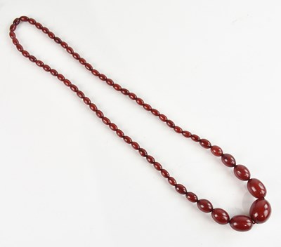 Lot 1569 - A cherry amber coloured bead necklace, length...
