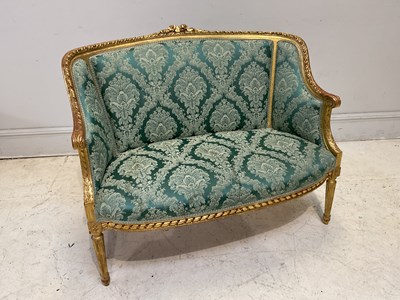 Lot 1097 - A Louis XV style giltwood sofa, upholstered in...