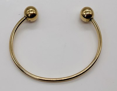 Lot 377 - A 9ct yellow gold torque bangle, internal...