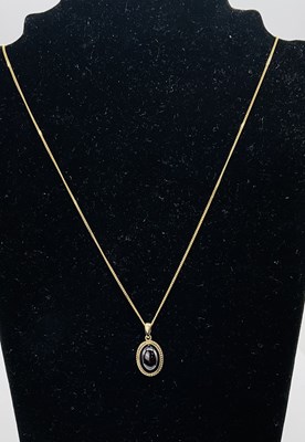Lot 397 - A 9ct yellow gold garnet cabochon pendant,...