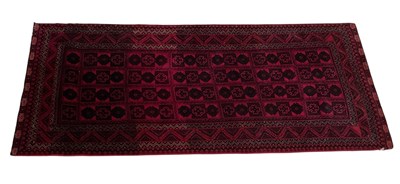 Lot 1213 - A red ground Baluch carpet, 245 x 110cm.