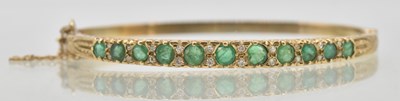 Lot 1448 - A 9ct yellow gold hinged bracelet, set with...