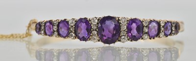 Lot 1449 - A yellow gold hinged bracelet, set with nine...
