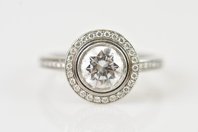 Lot 447 - CARTIER; a platinum diamond set halo ring, the...