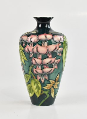 Lot 54 - MOORCROFT; a tall tapering vase in the...