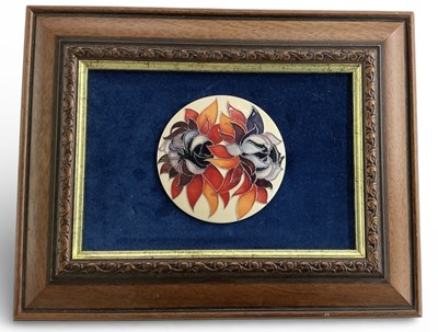 Lot 627 - MOORCROFT; a framed wall hanging circular...