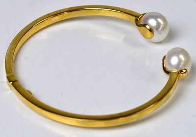 Lot 797 - An 18ct yellow gold hinged bangle set with a...