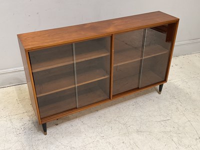 Lot 1141 - A mid century teak bookcase with four glass...