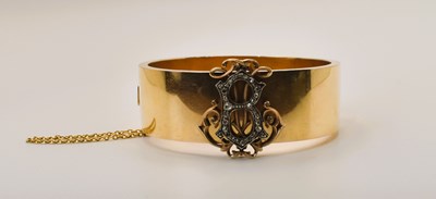 Lot 445 - A late 19th century yellow metal hinged broad...