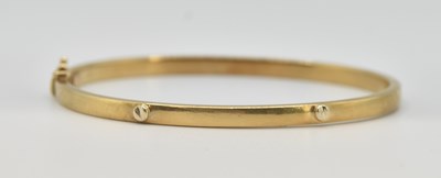 Lot 1462 - A 9ct yellow gold hinged bracelet, with faux...