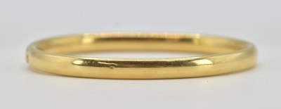 Lot 1444 - An 18ct yellow gold hinged bracelet with...