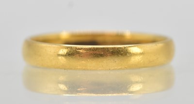 Lot 1211 - A 22ct yellow gold thin wedding band, size O,...