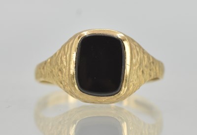 Lot 1298 - A 9ct yellow gold signet ring set with black...