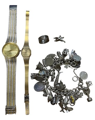Lot 1516 - A silver charm bracelet, with charms including...