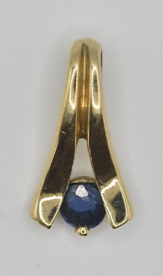 Lot 1391 - A small tension set cut sapphire in a 9ct gold...
