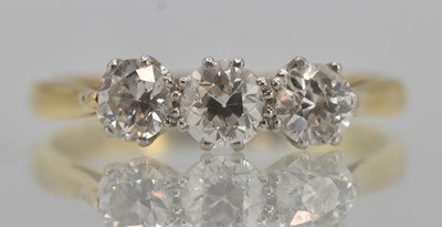 Lot 1329 - An 18ct yellow gold three stone diamond set...