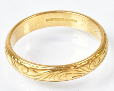 Lot 771 - An 18ct yellow gold wedding band, with scroll...