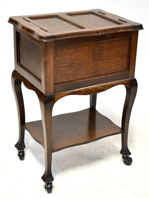 Lot 49 - A 1930s oak sewing table with lift-up top and...