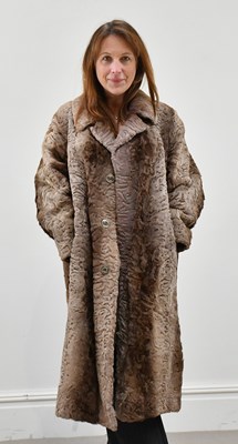 Lot 1381 - A knee-length tan and brown sheepskin coat,...