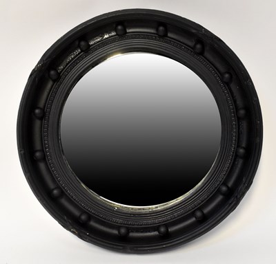 Lot 74 - A black painted Regency-style circular wall...
