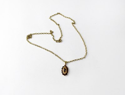 Lot 1023 - A 9ct yellow gold oval floral pendant set with...