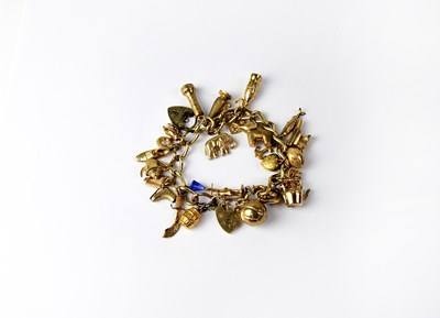 Lot 979 - A 9ct yellow gold link charm bracelet with...