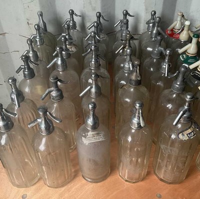 Lot 73 - Thirty glass soda syphons with metal or chrome...