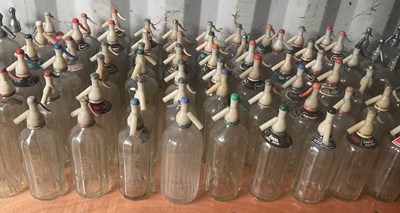 Lot 74 - Sixty glass soda syphons with plastic tops,,...