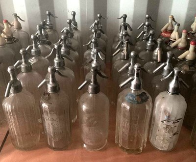 Lot 77 - Thirty glass soda syphons with metal or chrome...