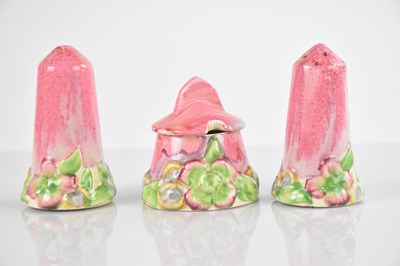 Lot 397 - CLARICE CLIFF, a three piece cruet, decorated...