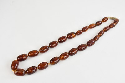 Lot 308 - A cherry amber coloured beaded necklace,...