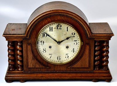 Lot 110 - A 1930s oak cased mantel clock, the silvered...