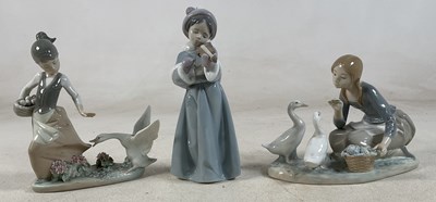 Lot 200 - LLADRO; three figures of a young girl feeding...