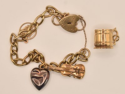 Lot 1518 - A 9ct yellow gold charm bracelet with padlock...